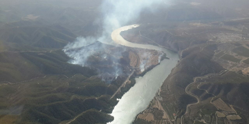Treball intens dels Bombers per evitar que el foc salte a l’altre costat del riu Ebre